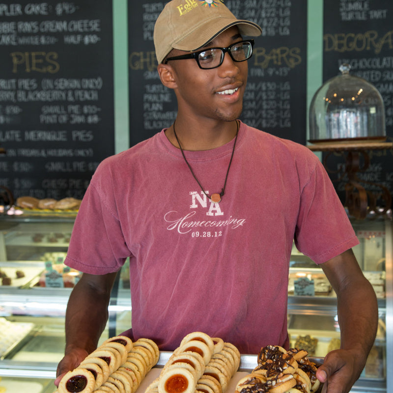A friendly worker holds cookies above the counter at Sugaree's