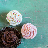 Chocolate, strawberry and vanilla cupcakes on green countertop