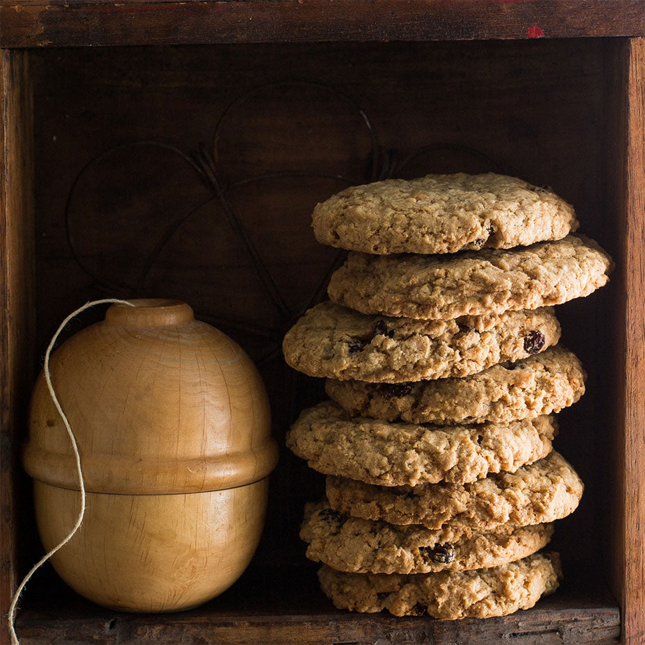 Stacked oatmeal raisin cookies on a wooden shelf