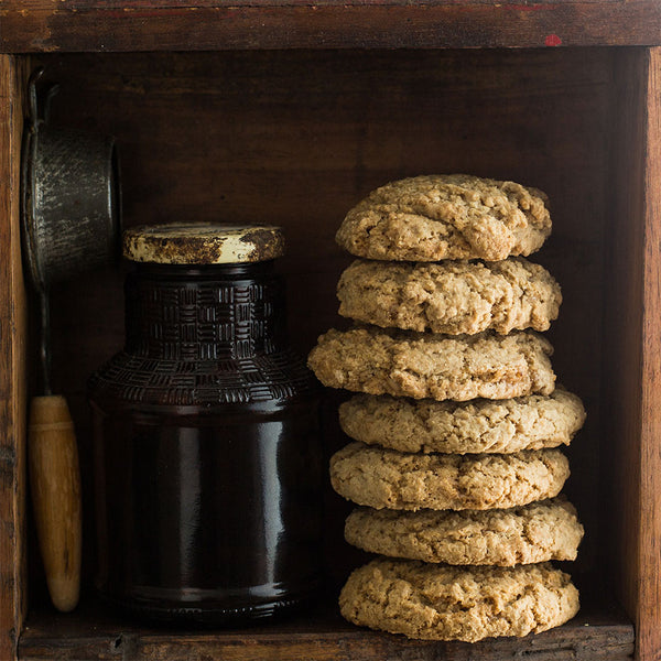 Oatmeal toffee cookies stacked on a wooden shelf