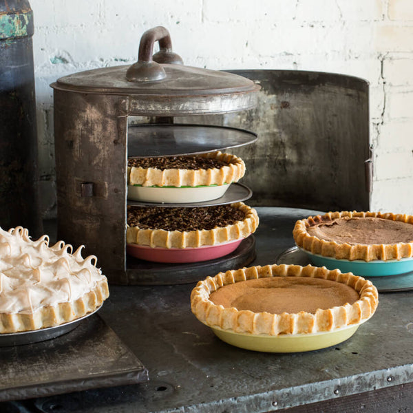 Multiple pies on a metal table top with different trays