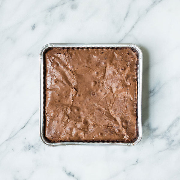 Tray of plain brownies on a marble countertop