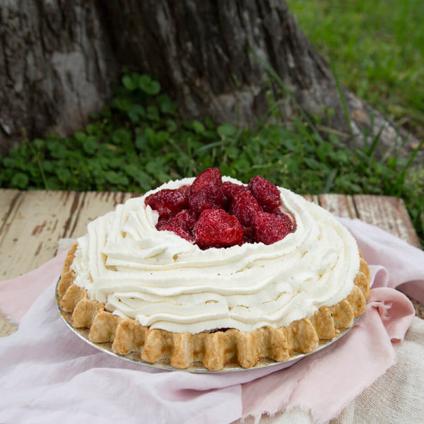 Strawberry pie on a pink table cloth, outside and in front of a tree