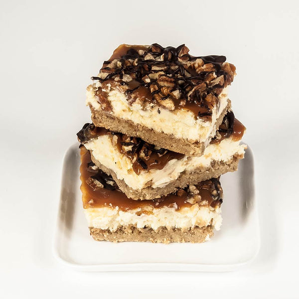Turtle cheesecake slices stacked on a white plate