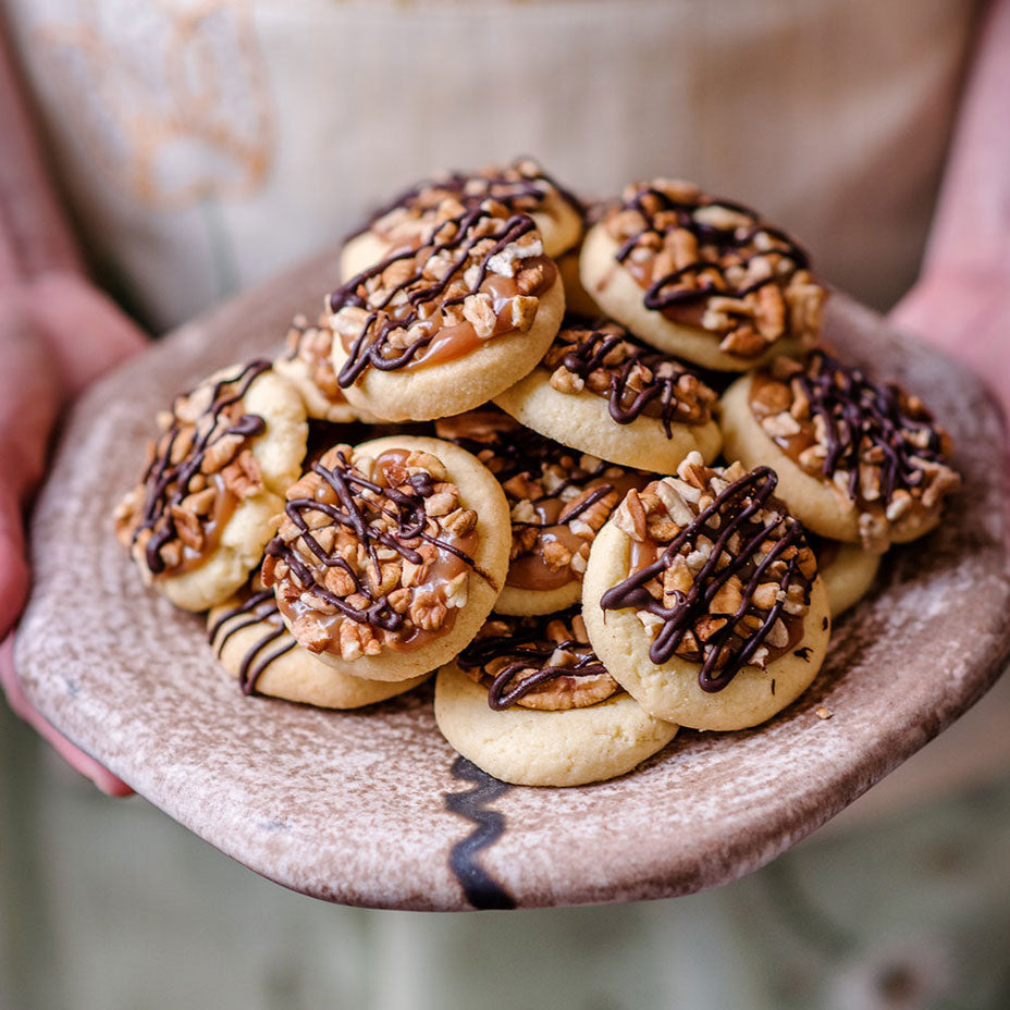 Person holding a plate of turtle tarts