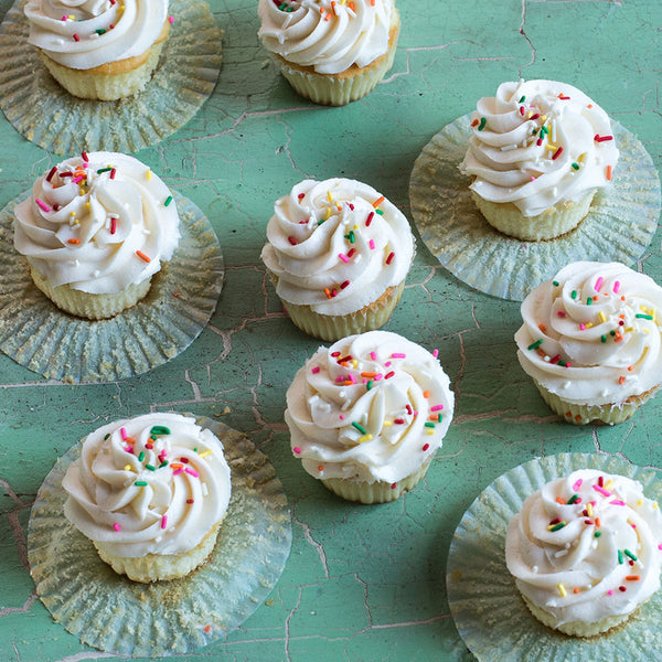 Vanilla cupcakes on a green countertop