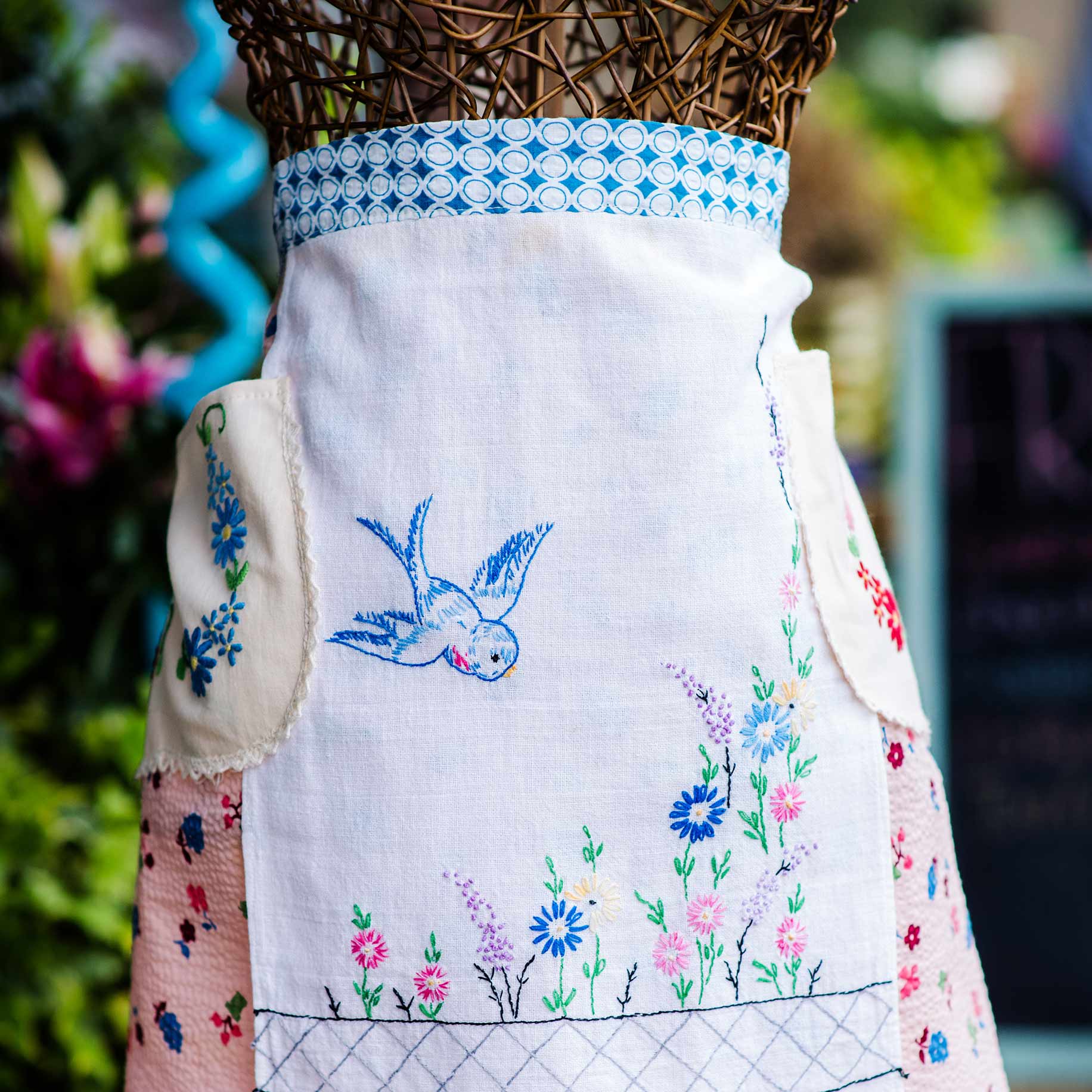 an apron embroidered with a blue bird design