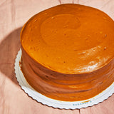 Sugaree’s Caramel Cake  on pink linen with a branded cake tray 