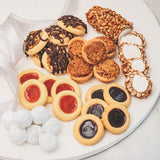 Assorted Sugaree’s small cookies and tarts on a white plate with ribbon