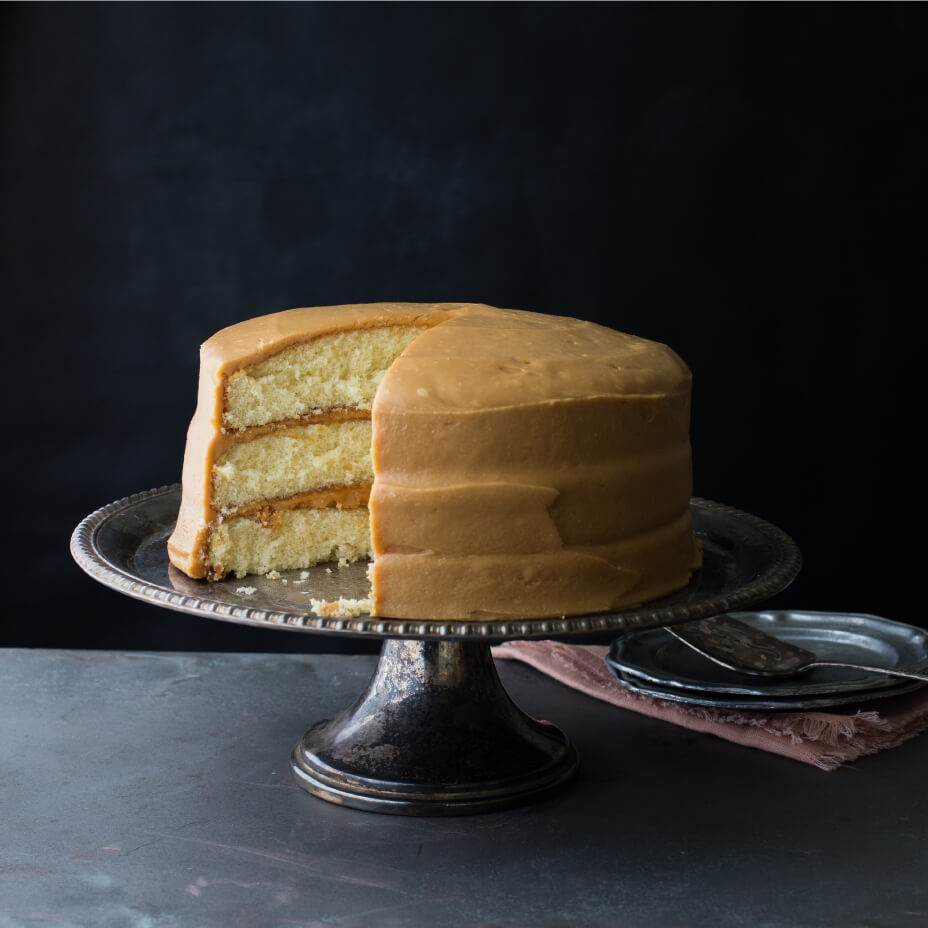 Caramel cake on a metal tray and concrete countertop