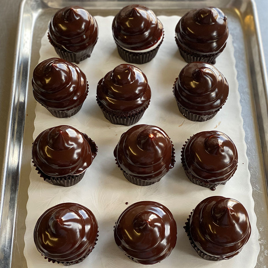 A dozen ding dong cupcakes on baking sheet