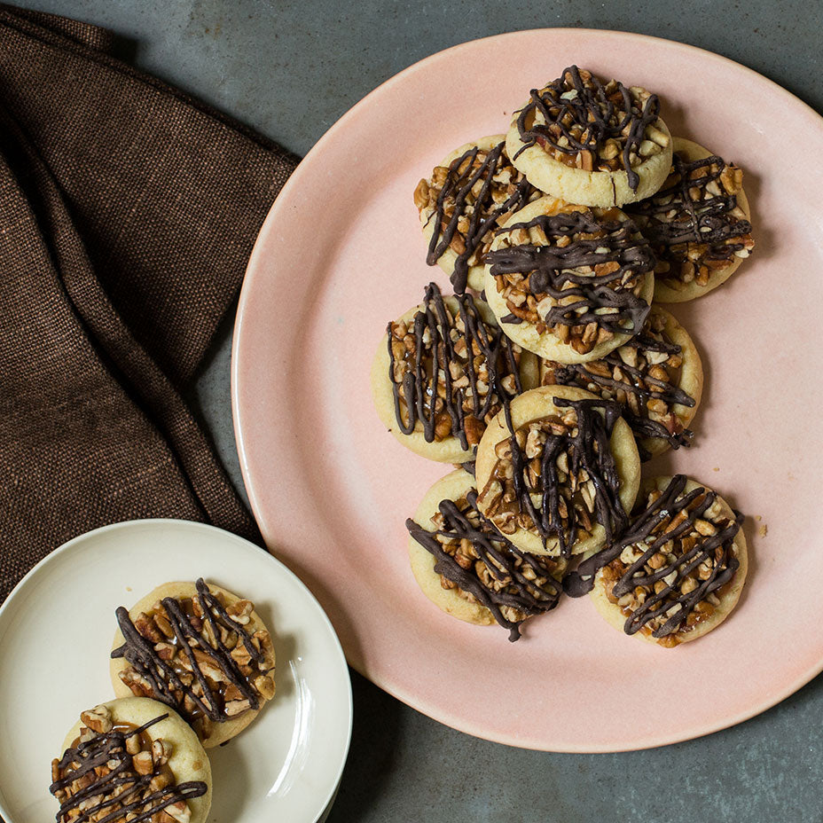 Turtle tarts on white and pink plates on top of a brown table cloth