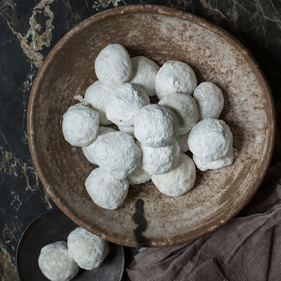 Bowl of wedding cookies on top of a marble countertop