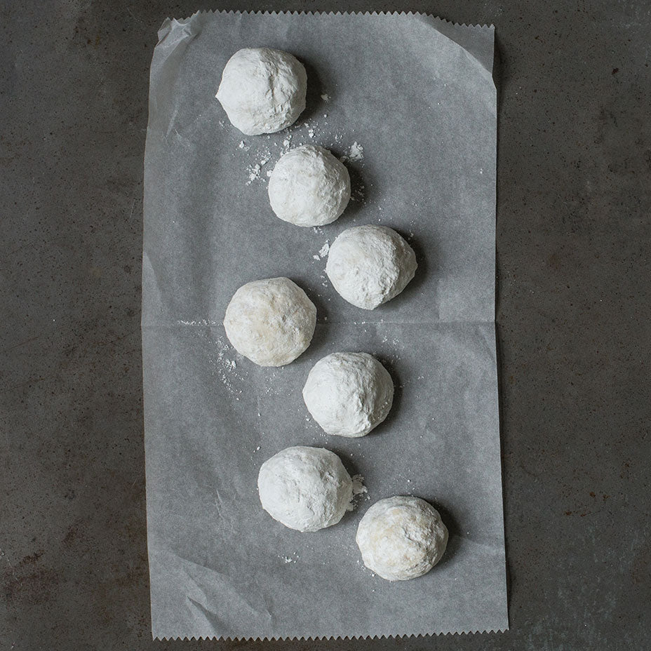 Eight wedding cookies on a concrete countertop
